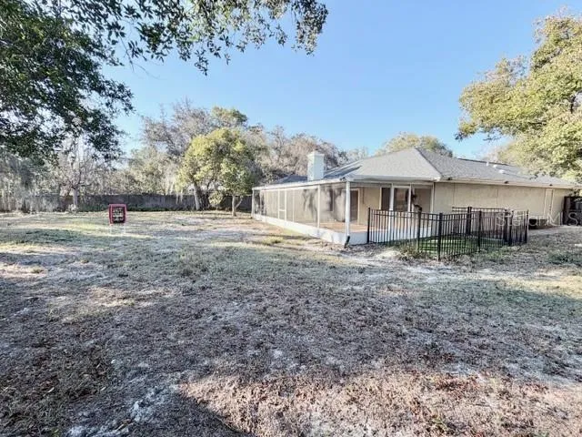 a view of a house with a yard and hanging chair
