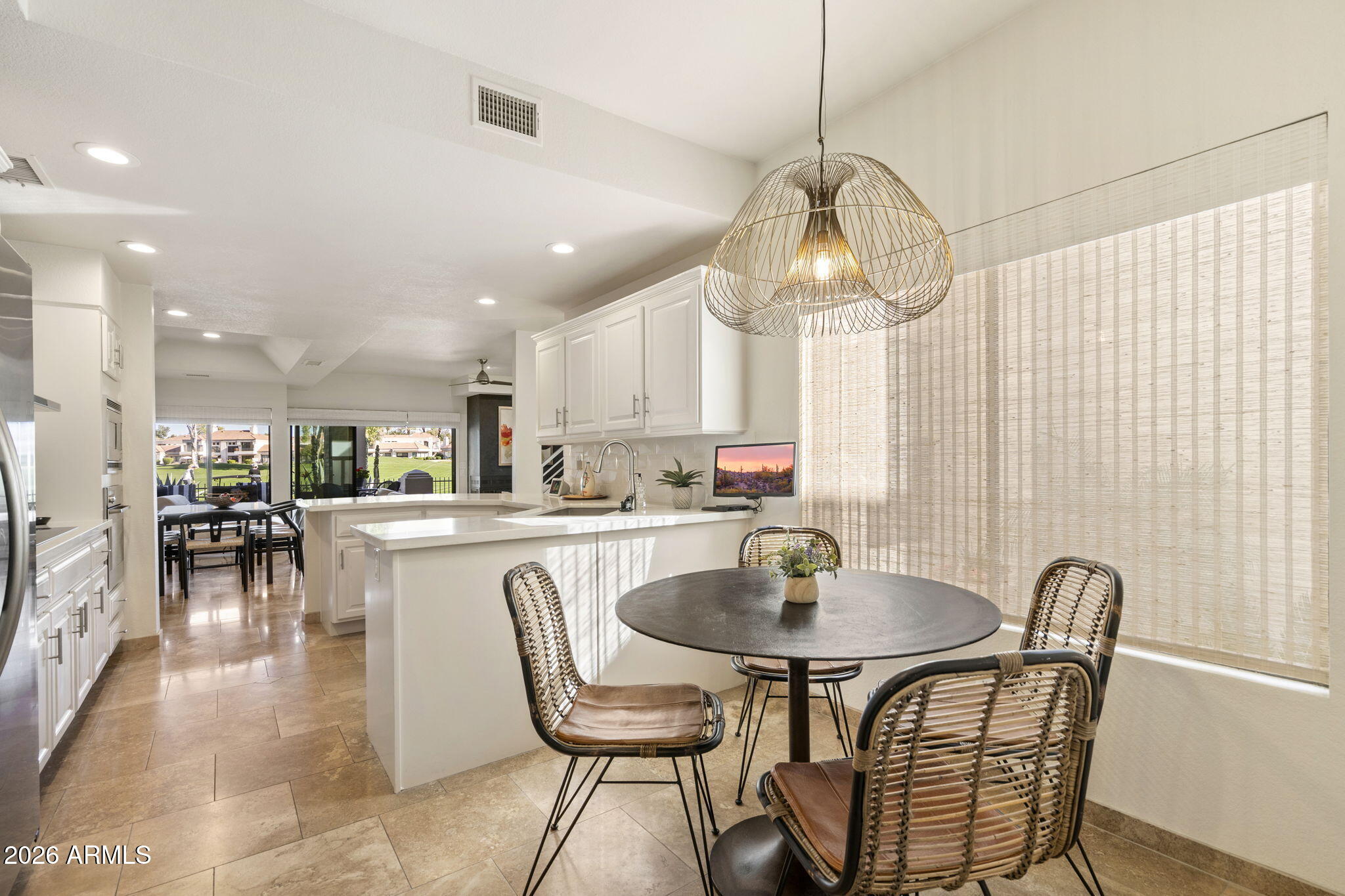 7272 East Gainey Ranch Road, Unit 12 Scottsdale, AZ 85258 - Photo 6 of 28 a kitchen with stainless steel appliances a dining table chairs stove and cabinets