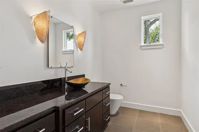 a bathroom with a granite countertop sink a toilet and mirror