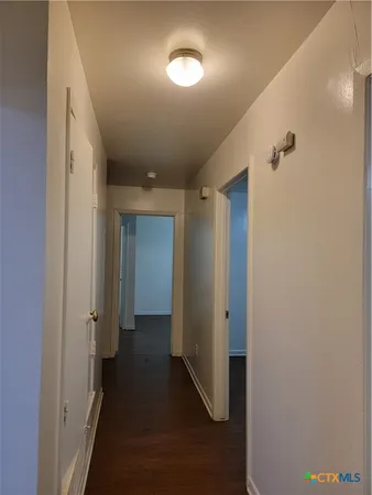 a view of a hallway with wooden floor