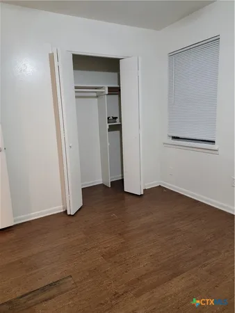 an empty room with wooden floor and closet