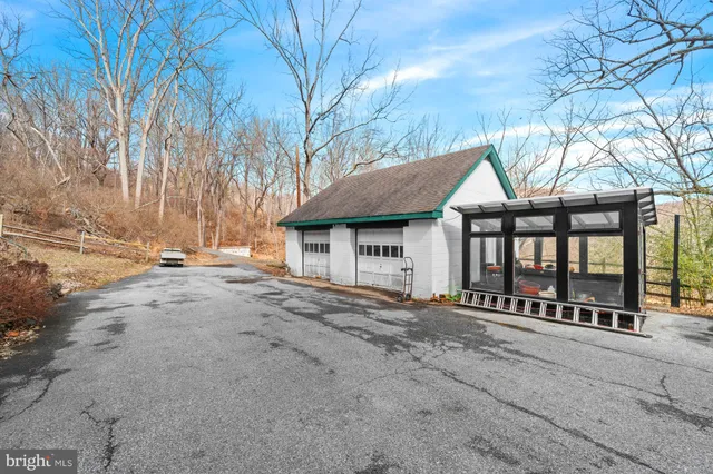 a view of a white house with a yard and large tree