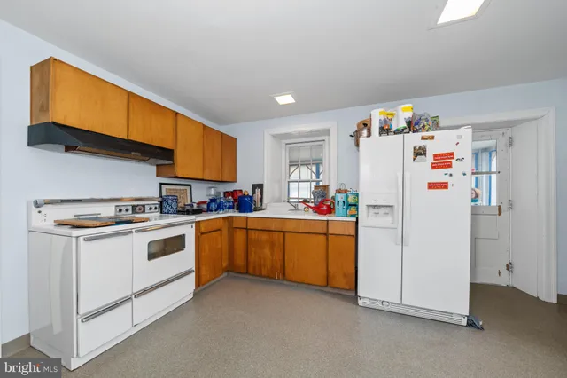 a kitchen with refrigerator a stove a sink a microwave and cabinets