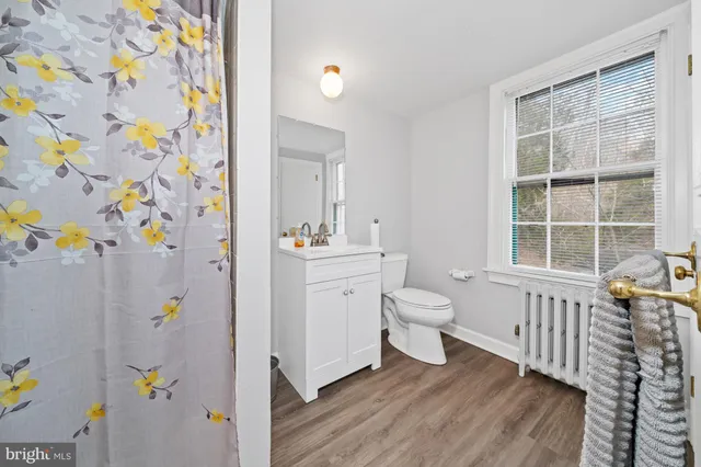 a bathroom with a sink a toilet and a window