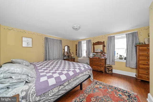 a bedroom with a bed and dresser with mirror