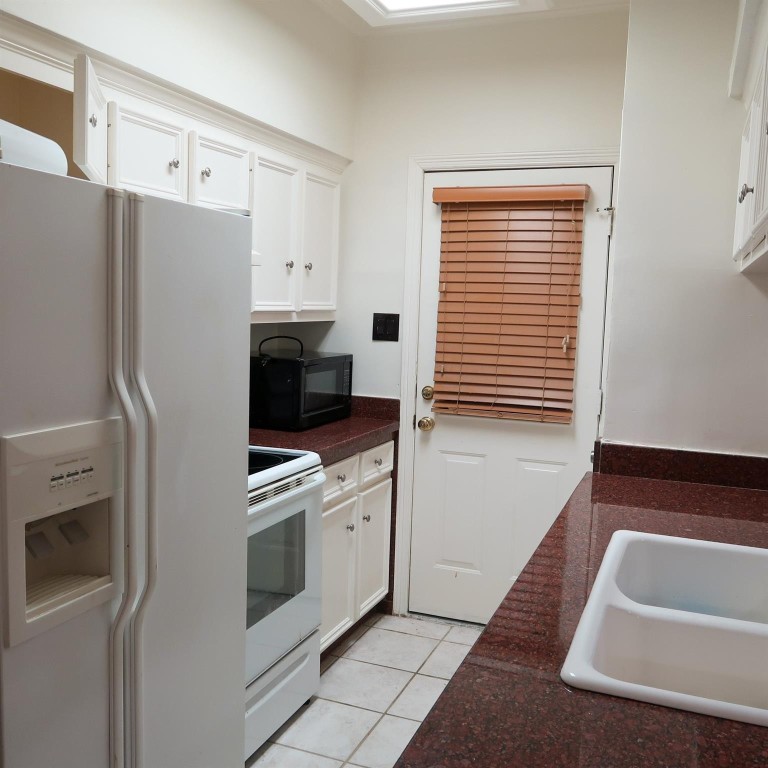 3600 Jeanetta Street, Unit 1301 Houston, TX 77063 - Photo 7 of 21 a kitchen with white cabinets and white appliances