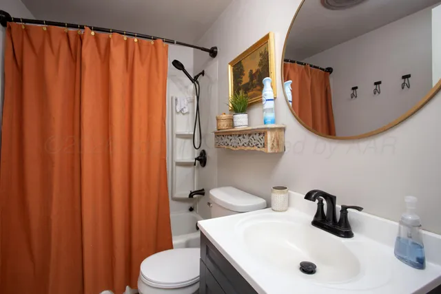 a bathroom with a sink a toilet and shower curtain