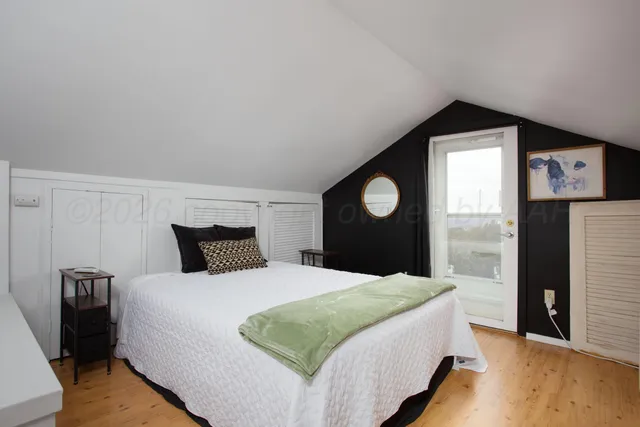 a bedroom with a bed and a large mirror