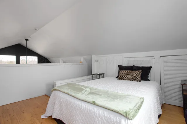 a bedroom with a large bed and a lamp