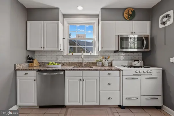 a kitchen with a sink a stove and cabinets