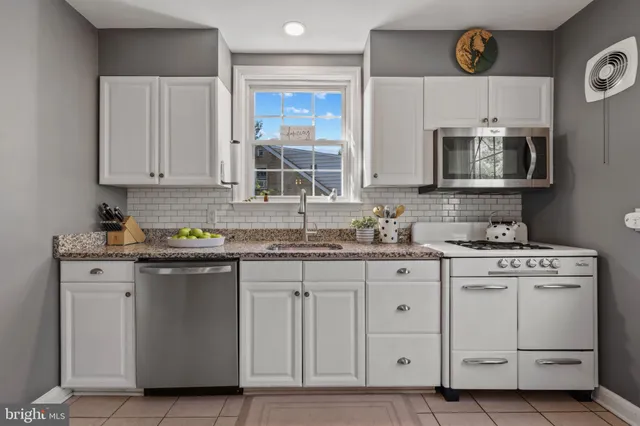 a kitchen with a sink a stove and cabinets