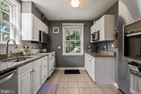 a kitchen with stainless steel appliances granite countertop a refrigerator a stove and a sink