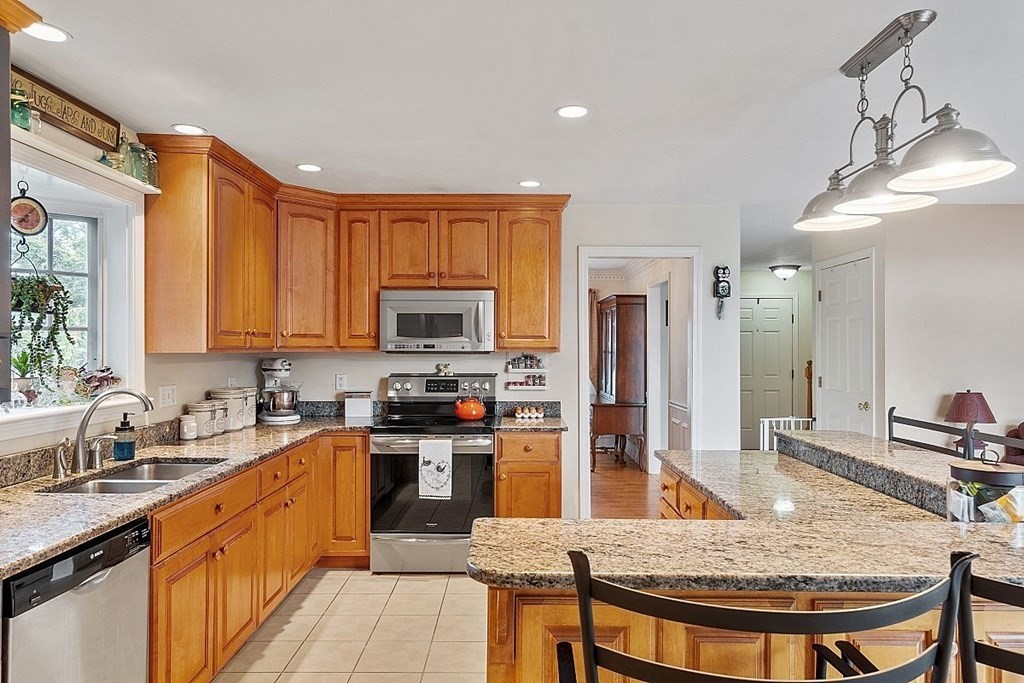 299 South Meadow Road Lancaster, MA 01523 - Photo 21 of 41 a kitchen with stainless steel appliances granite countertop a sink stove and refrigerator