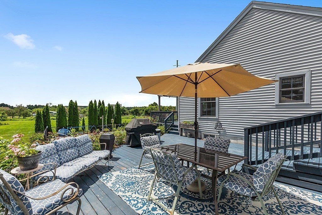 299 South Meadow Road Lancaster, MA 01523 - Photo 41 of 41 a view of a patio with couches table and chairs under an umbrella