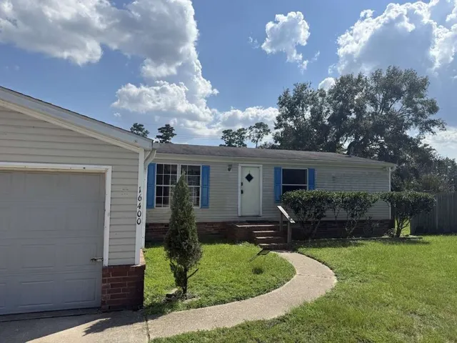 a front view of house with a garden