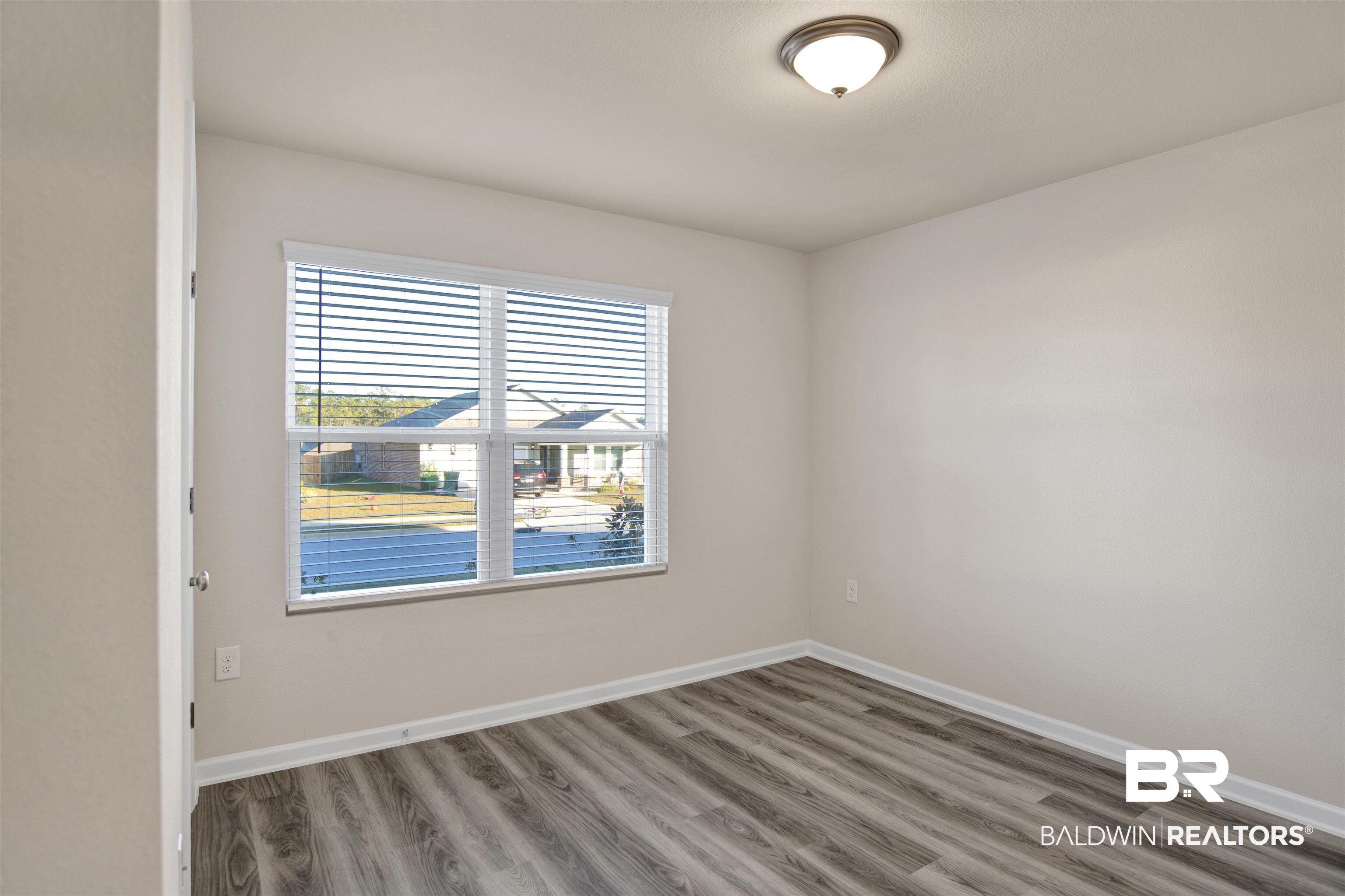 32038 Lyon Road Daphne, AL 36527 - Photo 13 of 30 Spare room featuring wood finished floors and baseboards