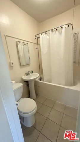 a white toilet sitting next to a shower curtain