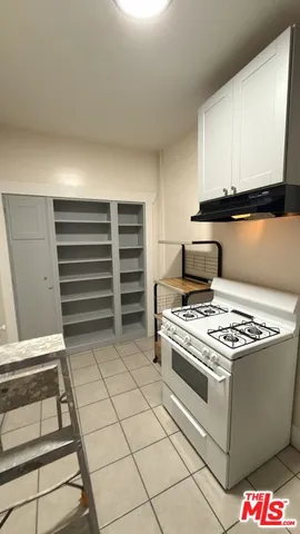 a kitchen with white cabinets and appliances