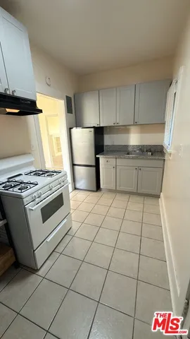 a kitchen with a stove a refrigerator and cabinets