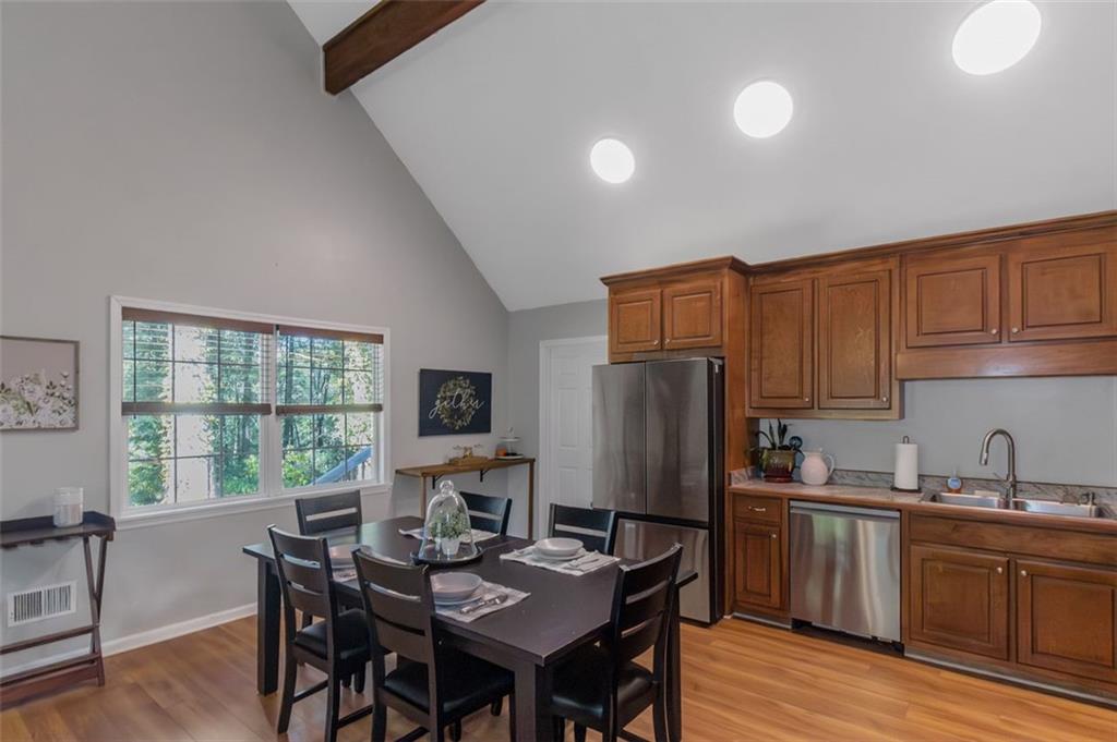 150 Mackey Road McDonough, GA 30252 - Photo 14 of 38 a kitchen with stainless steel appliances granite countertop a refrigerator a sink dishwasher a dining table and chairs with wooden floor