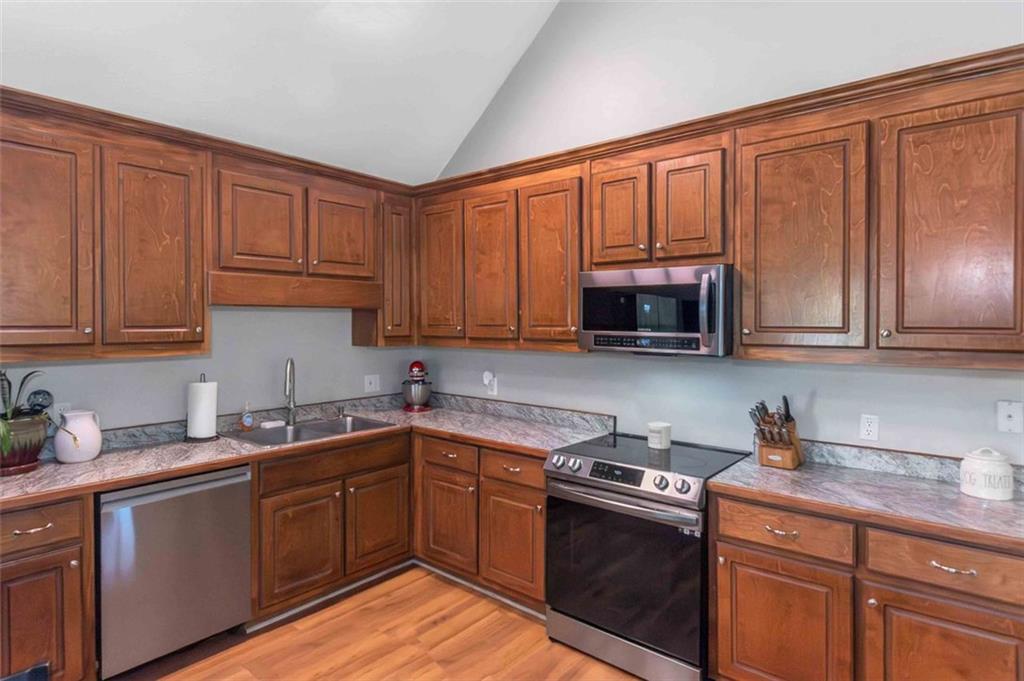150 Mackey Road McDonough, GA 30252 - Photo 18 of 38 a kitchen with stainless steel appliances granite countertop a sink dishwasher stove and cabinets with wooden floor
