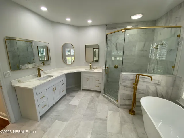 a bathroom with a double vanity sink a mirror a bathtub and shower