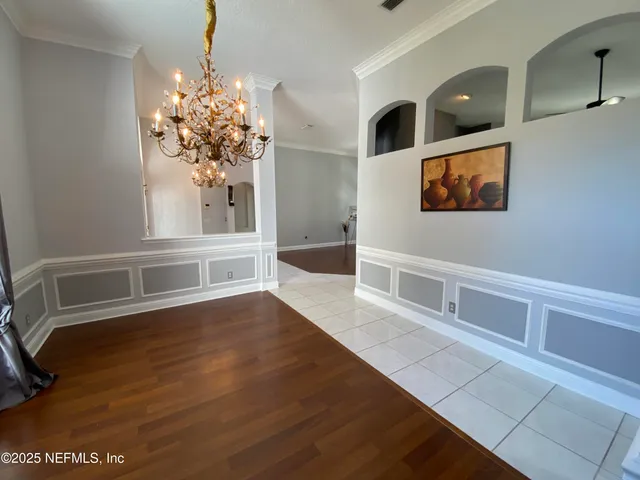a view of a room with wooden floor and chandelier