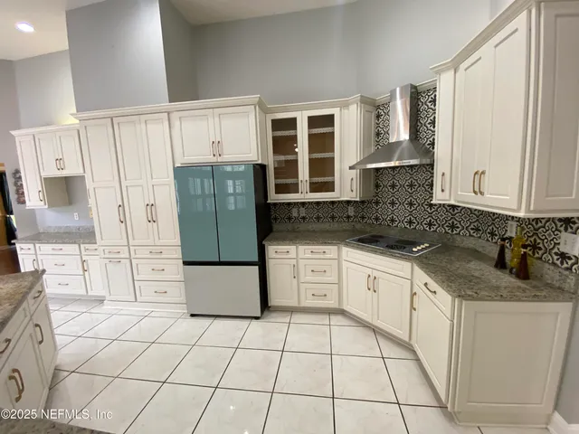 a kitchen with a refrigerator sink and cabinets