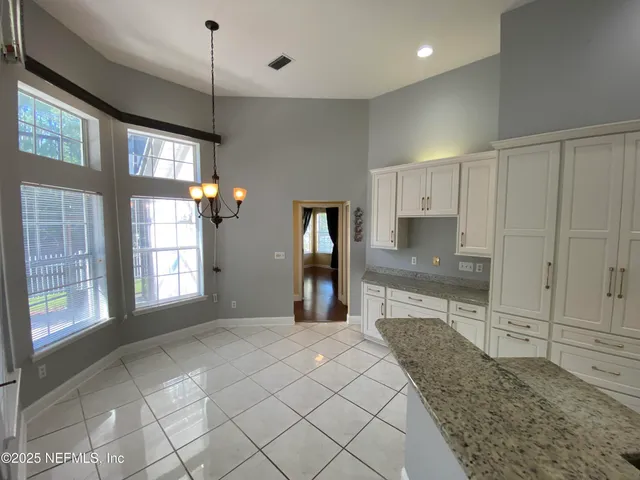 a large kitchen with kitchen island granite countertop a stove a sink and a granite counter tops