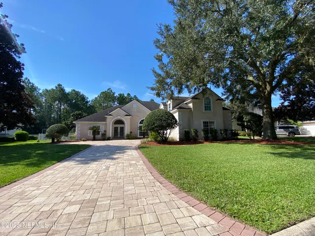 a front view of a house with yard and green space