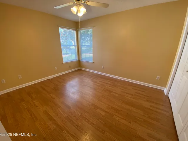 a view of an empty room with wooden floor