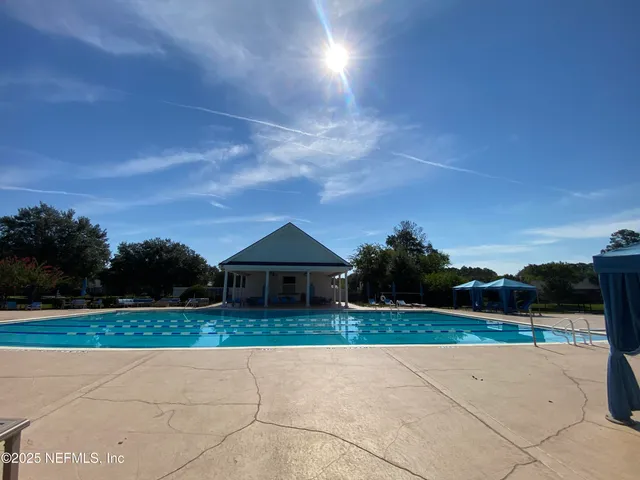 a view of house with outdoor space and tall trees