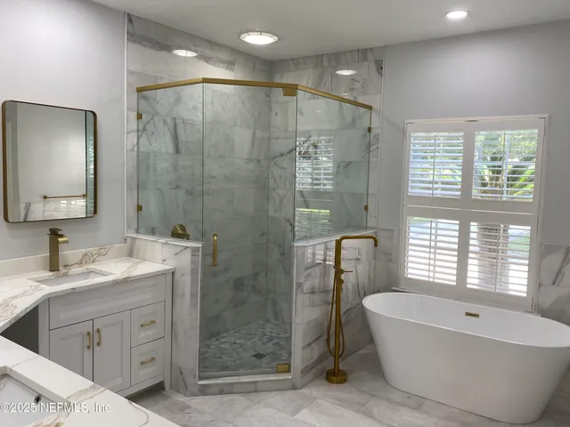 a bathroom with a double vanity sink large mirror and shower