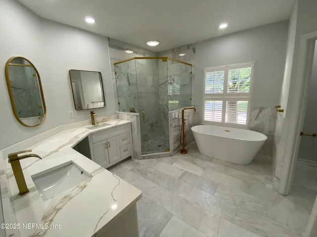 a spacious bathroom with a double vanity sink a mirror and a bathtub