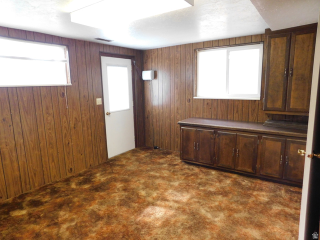 2148 Carolyn Way Bountiful, UT 84010 - Photo 25 of 40 Interior room featuring wood-panel walls, patterned carpet, and multiple windows