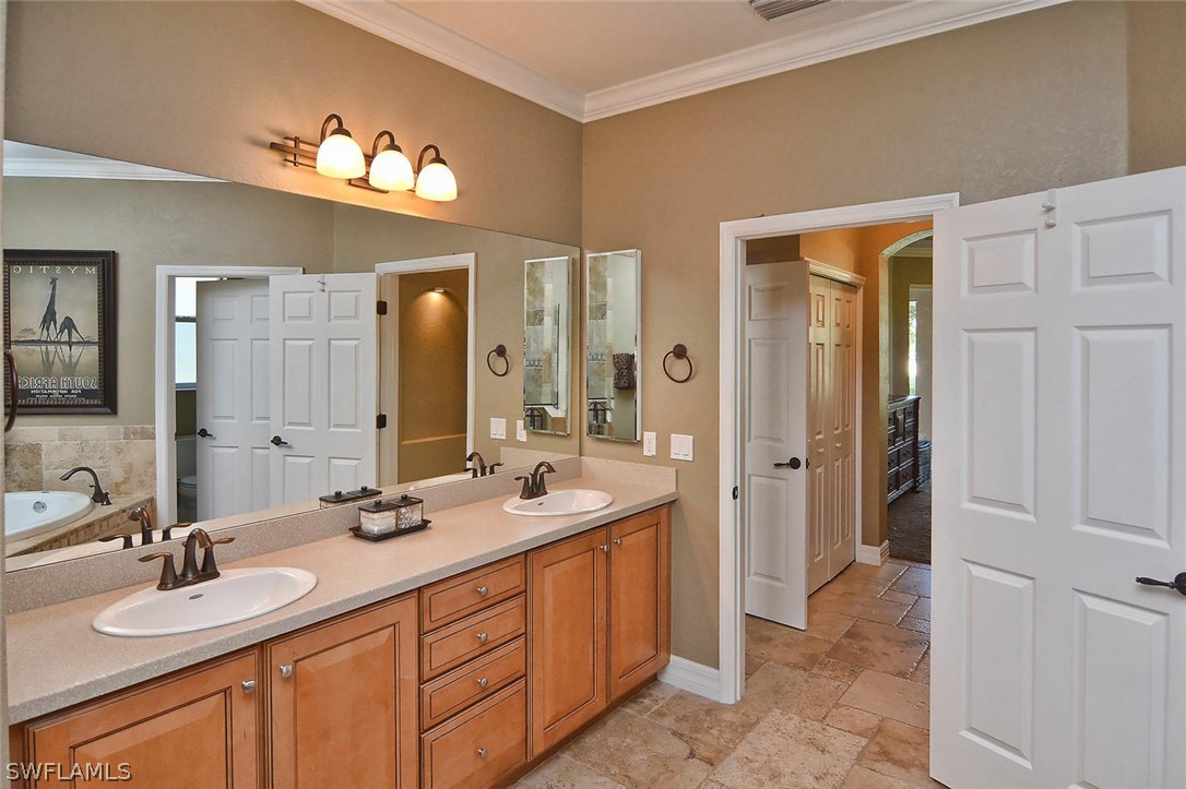 12357 Rock Ridge Lane Fort Myers, FL 33913 - Photo 17 of 25 a spacious bathroom with a double vanity sink and a mirror