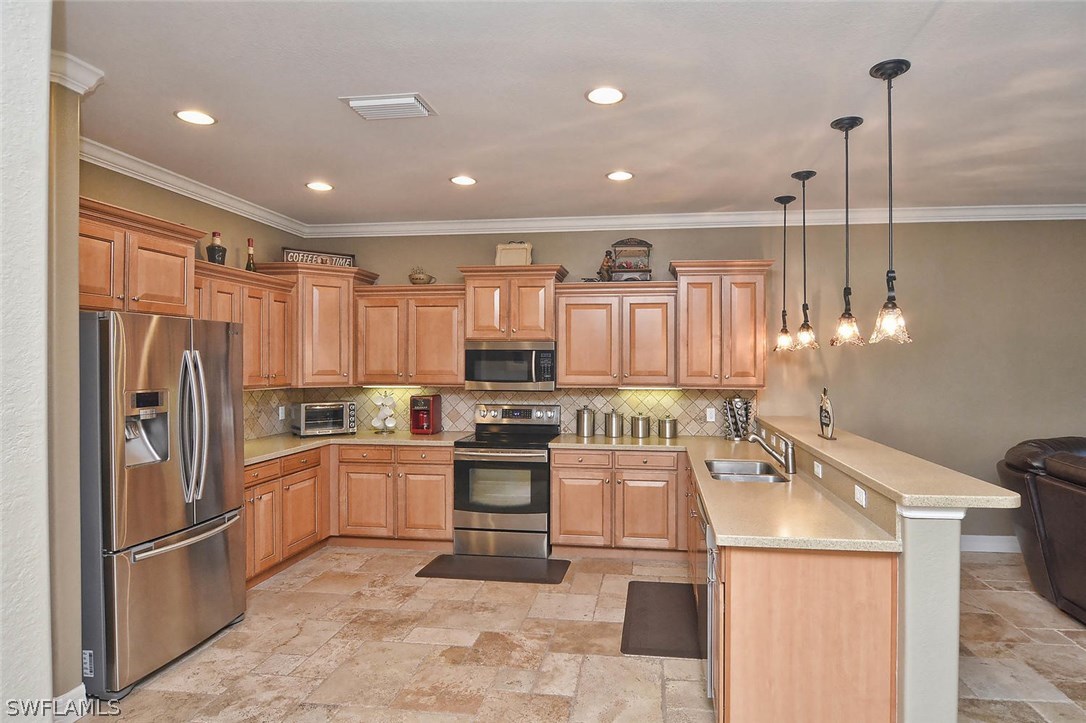 12357 Rock Ridge Lane Fort Myers, FL 33913 - Photo 19 of 25 a kitchen with kitchen island granite countertop a sink appliances and cabinets