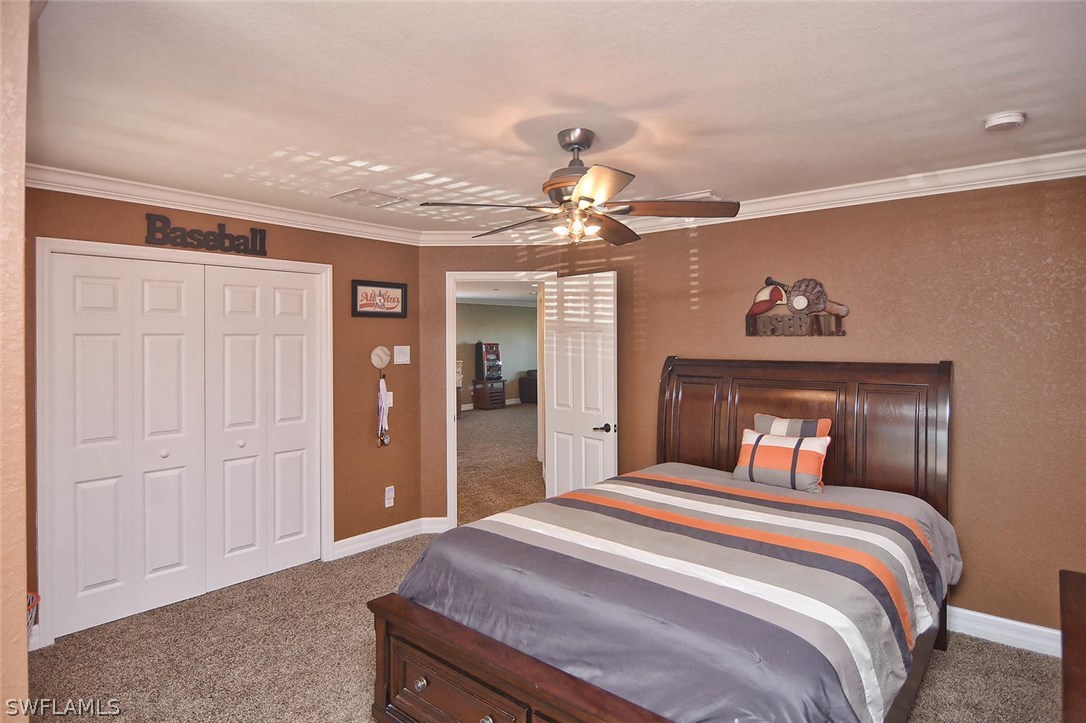 12357 Rock Ridge Lane Fort Myers, FL 33913 - Photo 9 of 25 a bedroom with a large bed and a chandelier