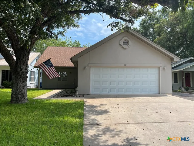 a front view of house with yard and trees