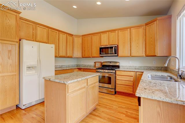 189 Avocet Loop Colorado Springs, CO 80921 - Photo 6 of 32 Granite countertops, oak cabinets, and an island