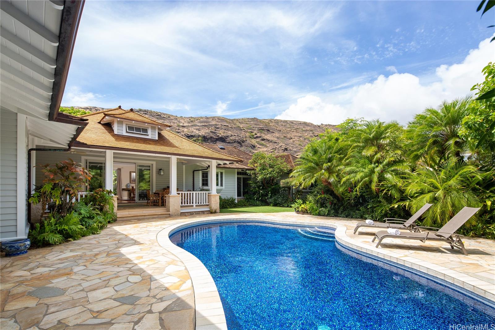 a view of a house with pool and sitting area
