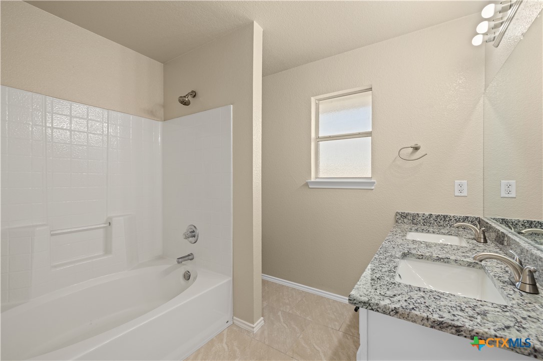 217 Timber Ridge Drive Nolanville, TX 76559 - Photo 13 of 25 a bathroom with a granite countertop sink and a bathtub