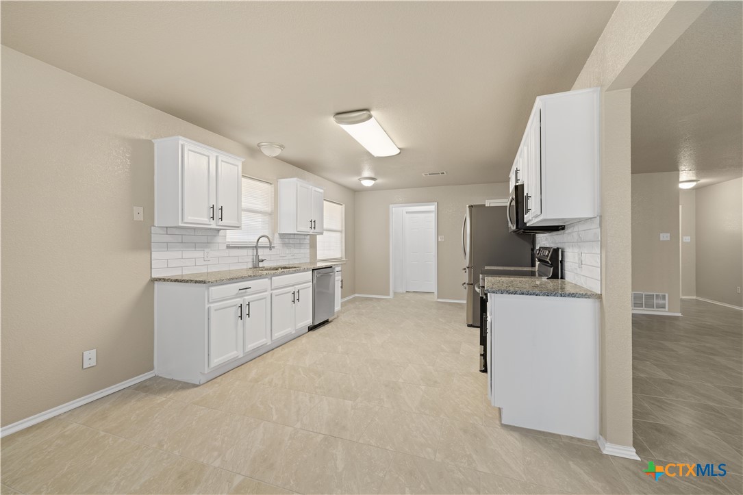 217 Timber Ridge Drive Nolanville, TX 76559 - Photo 9 of 25 a kitchen with a white cabinets stove and refrigerator