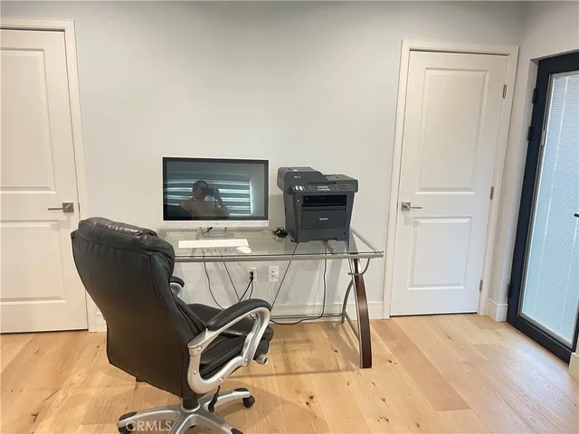 a view of a workspace with furniture and wooden floor