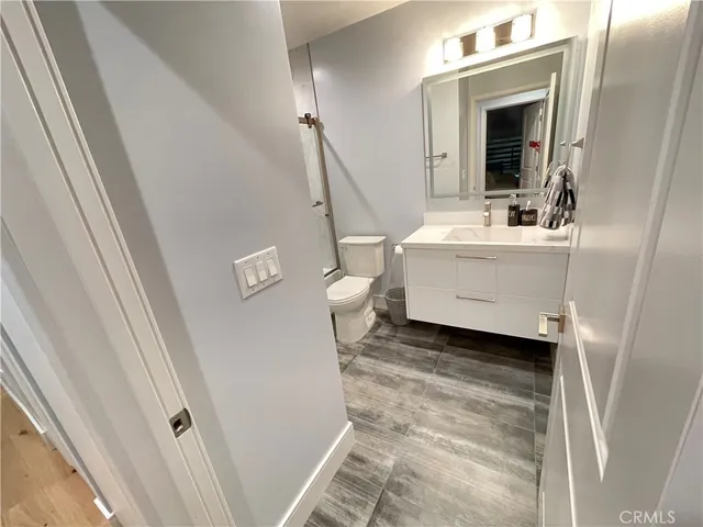 a bathroom with a sink a toilet and a mirror