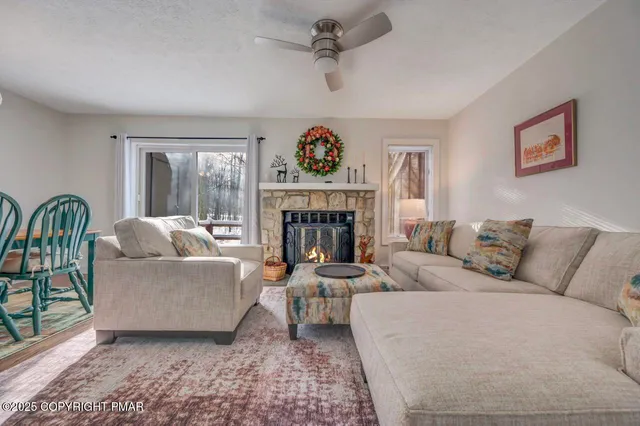 a living room with furniture a flat screen tv and kitchen view