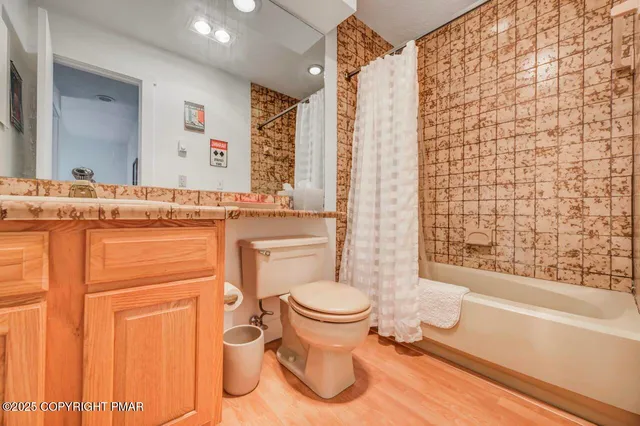 a bathroom with a granite countertop toilet sink and mirror