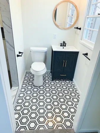 a bathroom with a granite countertop shower a mirror and toilet