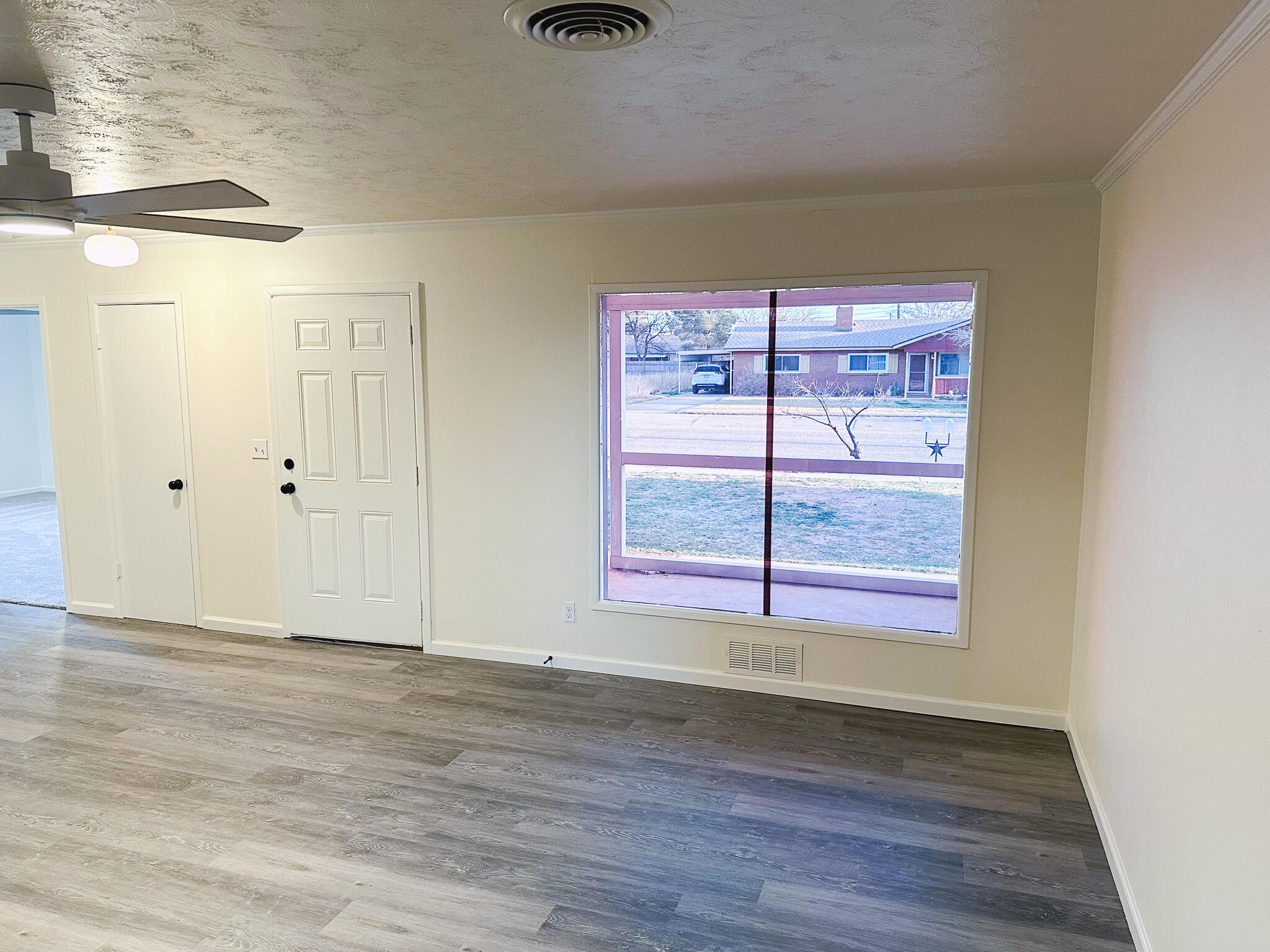 102 Northeast 25th Street Lamesa, TX 79331 - Photo 21 of 32 a view of an empty room with wooden floor and a window