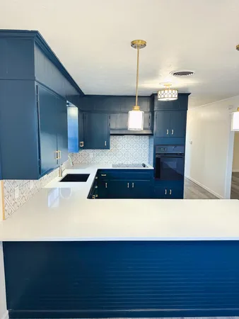 a kitchen with a sink and wooden floor